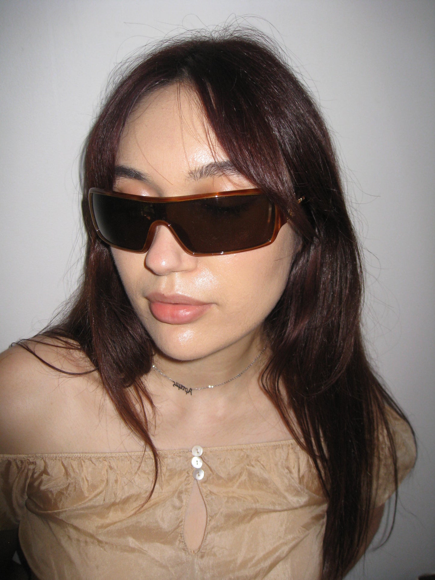 Person wearing large sunglasses with a neutral background